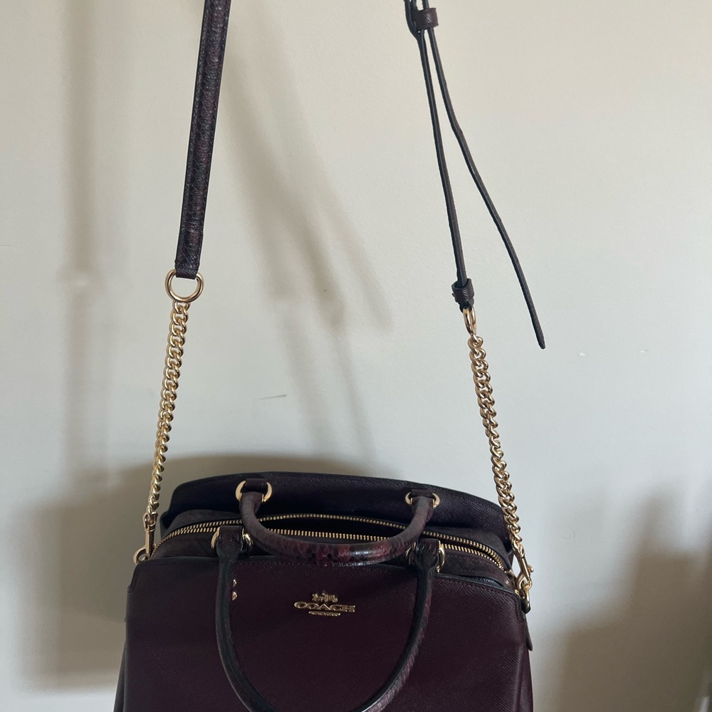 Beautiful Coach Cranberry color purse with snake skin design handles and inside